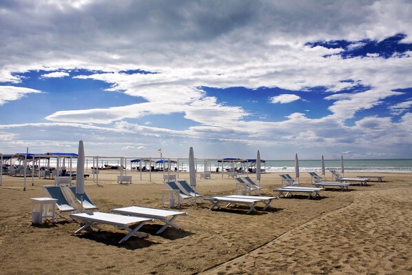 A beach with sun loungers and umbrellas, a clear sky, and the ocean in the background. - Casa Colombo with Garden In Forte Dei Marmi, Forte dei Marmi, Italy (Forte dei Marmi)