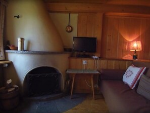 A cozy living room with a fireplace, a television, and a sofa. - Guarda Cuolms Schütz Appartement/Fewo,   Guarda Cuolms Schütz by Interhome (Lenzerheide)