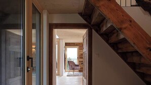 A wooden staircase leading to a balcony with a chair and a rug on the floor. - Alphütte Briula Appartement/Fewo, Dusche, WC, 3 Schlafräume by Interhome (Valbella)