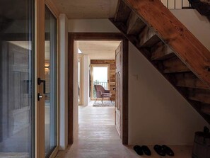 A wooden staircase leading to a balcony with a chair and a rug on the floor. - Alphütte Briula Appartement/Fewo, Dusche, WC, 3 Schlafräume by Interhome (Valbella)