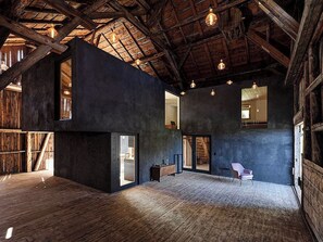 Un interior espacioso con vigas de madera a la vista, ventanas amplias y un diseño moderno.