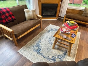 A cozy living room with a sofa, a coffee table, and a fireplace. - The Narrows on Lawrence Lake
Privacy, Hot Tub, Beach, Dock, Quick Trail Access (Outing)