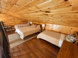A wooden-paneled room with two beds, a small table, and a bench. - The Narrows on Lawrence Lake
Privacy, Hot Tub, Beach, Dock, Quick Trail Access (Outing)