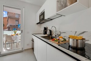 Eine moderne Küche mit Einbauofen, Spüle und Essbereich mit Tisch und Stühlen.