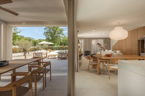 Ein modernes Interieur mit Essbereich, Küche und Blick ins Freie.