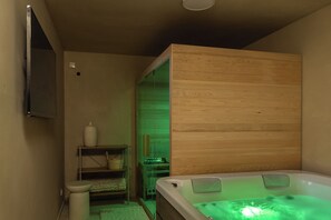 A bathroom with a wooden wall, a bathtub, a toilet, and a shelf with toiletries. - Nareo Villa Collection - Villa Orla, Labin, Croatia (Labin)