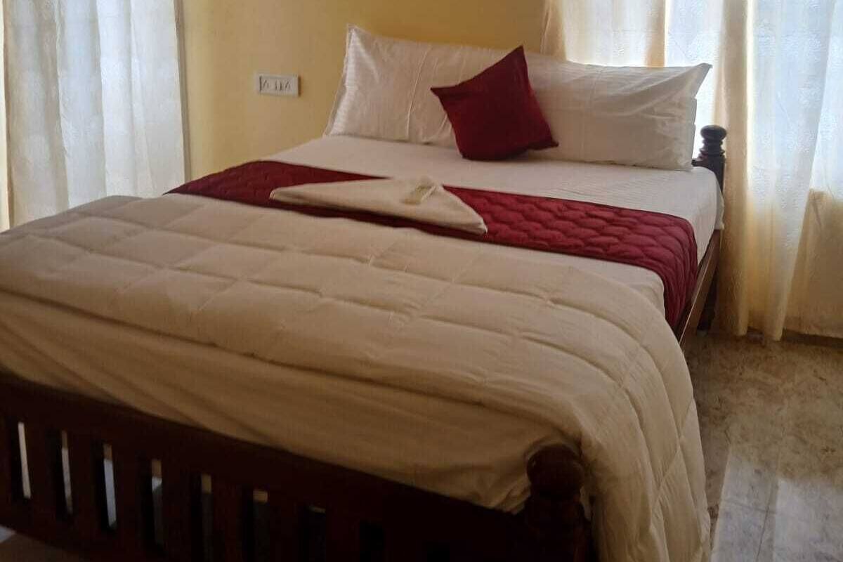 Un dormitorio con cama, cortinas y un enchufe.