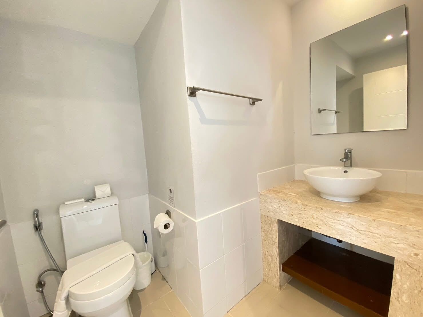 Une salle de bain moderne équipée de toilettes, d’un bidet et d’un lavabo avec un miroir au-dessus.