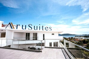 Un edificio moderno con el nombre 'AruSuites' bien visible.