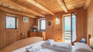 A wooden cabin room with two beds, a window, a mirror, and a door leading outside. - Private Green Oasis - Terrace, Tenno, Italy (Tenno)