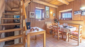 A wooden interior with a dining table set for four, a staircase, and framed pictures on the walls. - Private Green Oasis - Terrace, Tenno, Italy (Tenno)