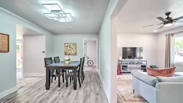 Un espace de vie moderne comprenant un coin repas, un canapé et un ventilateur de plafond.