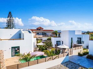A modern residential complex with multiple buildings, outdoor seating, and a swimming pool. - Gemini Villas- Harmony Villa by Interhome (Rhodos City)