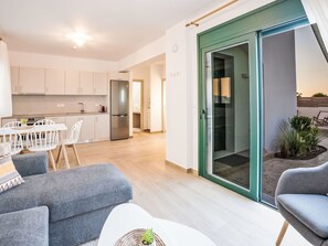 Eine moderne Wohnung mit Essbereich, Küche und einer Schiebetür zu einem Balkon.