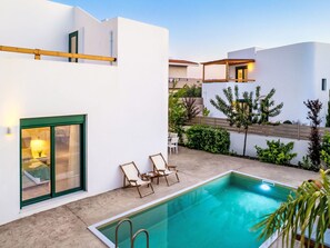 A modern pool area with a clear pool, a lounge chair, and a small table. - Gemini Villas- Harmony Villa by Interhome (Rhodos City)