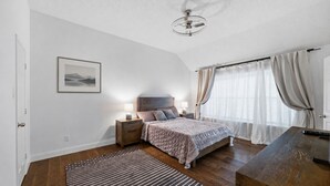 A bedroom with a bed, bedside tables, a nightstand, a ceiling fan, a window with curtains, and a framed picture on the wall. -     Corporate Friendly Frisco Home Fast WiFi Office Near Major Headquarters (Frisco)