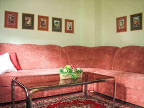 A red sofa with a metal coffee table and a basket of flowers. - Herlíkovice by Interhome (Vrchlabi)