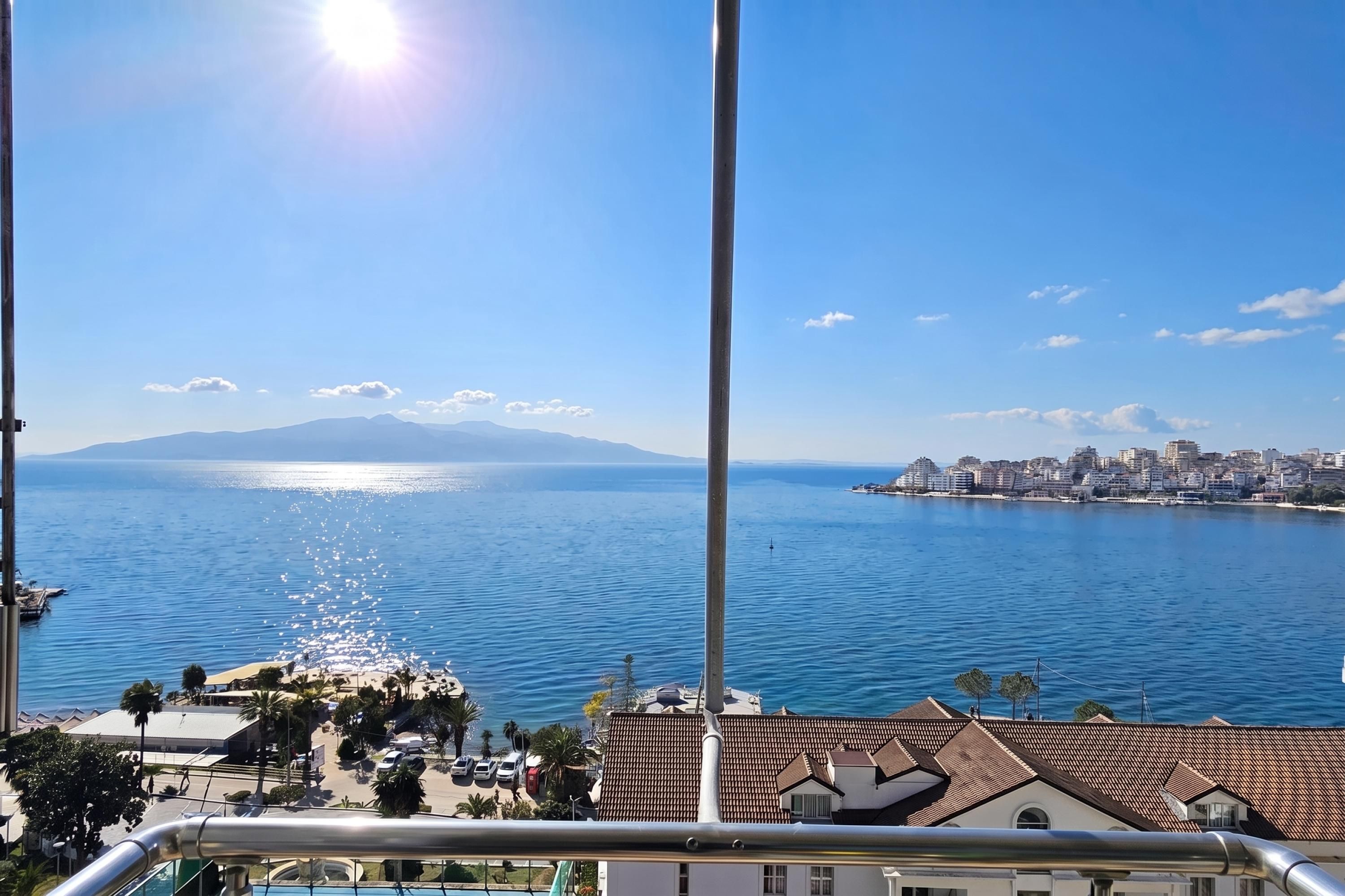 Un paisaje urbano costero con vistas claras al mar, una montaña al fondo y el perfil del horizonte de la ciudad.