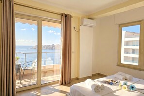 Hotellihuone, jossa on parveke, sänky, ikkuna ja ilmastointilaite.