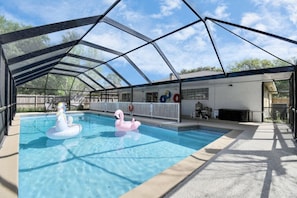 Ein Hallenbad mit überdachtem Bereich, zwei aufblasbaren Schwänen und einem Rettungsring.