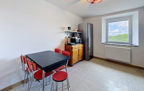 A compact kitchen with a dining table and chairs, a refrigerator, and a window with a view. - 2 bedroom beautiful apartment in Lachamp Raphael (Lachamp Raphael)