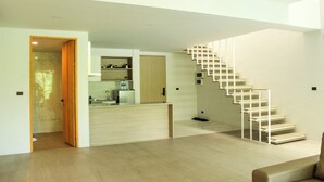 A modern interior with a staircase, a kitchen area, and a wooden floor. - 2 Bedroom Unique Indoor Pool Villa (Bophut)