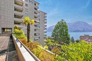 A modern building with balconies overlooking a body of water and mountains. - Smart Stay Lugano, Lugano, Switzerland (Lugano)