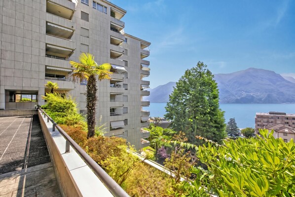 A modern building with balconies overlooking a body of water and mountains. - Smart Stay Lugano, Lugano, Switzerland (Lugano)