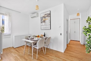 A modern dining area with a white table, chairs, and a fruit bowl. - Smart Stay Lugano, Lugano, Switzerland (Lugano)
