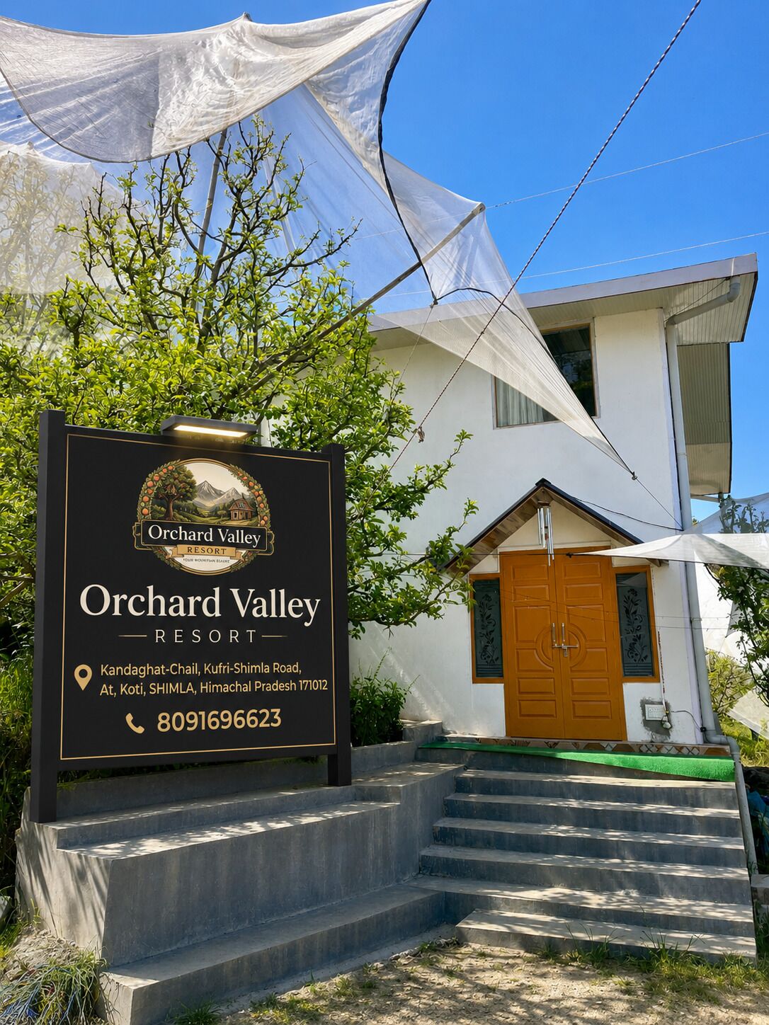 Cartell de l'Orchard Valley Resort, amb una vista clara dels escalons d'entrada i una façana d'edifici moderna.