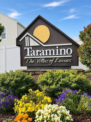 A sign for 'Taramino The Villas of Leves' with a house-shaped design and a sun symbol.