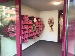 Ein Zimmer mit geometrischer Wandgestaltung, Teppichboden und einer Tür mit Griff.