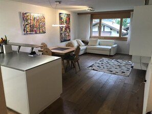 Eine moderne Küche mit Essbereich, einer Couch und Kunstwerken an den Wänden.