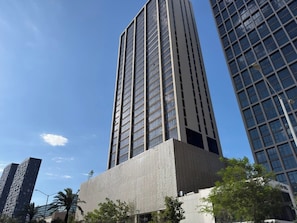 A tall building with a grid-like facade and a textured lower section.