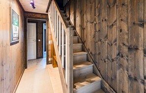 Eine Holztreppe führt zu einem Raum mit einer Tür.