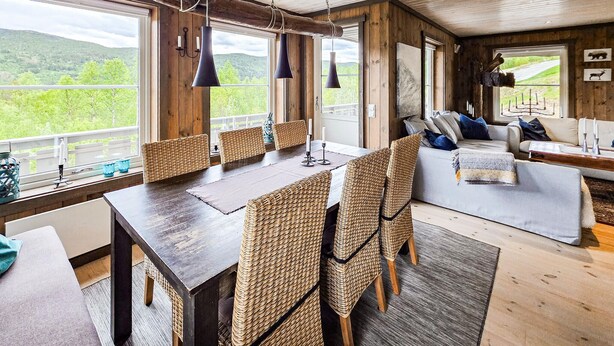 A rustic interior with a dining area, seating, and a view of greenery. - Amazing home in Hovet with sauna (Hovet)
