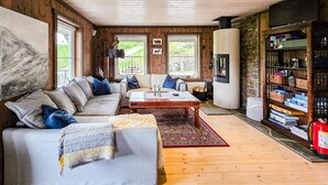A cozy living room with a sofa, coffee table, and fireplace. - Amazing home in Hovet with sauna (Hovet)