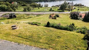 A rural landscape with a lake, mountains, and a road.
