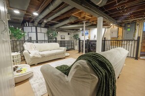 Un salon confortable avec un canapé, un fauteuil et une petite table sur laquelle est posée une couverture.