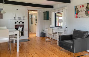 Ein modernes Wohnzimmer mit einer schwarzen Ledersofa, weißen Möbeln und Holzboden.