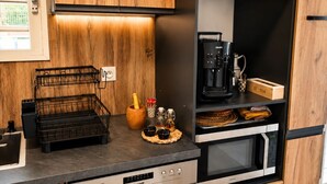 Una cocina moderna con armarios de madera, una cafetera y un microondas.