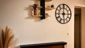 Una chimenea moderna con un reloj integrado y repisas encima.