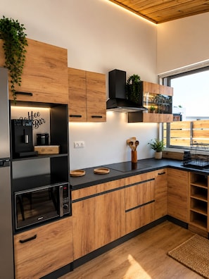A modern kitchen with wooden cabinets, a built-in oven, and a coffee bar. - The Eden of the Grande Montée (Sainte-Marie)