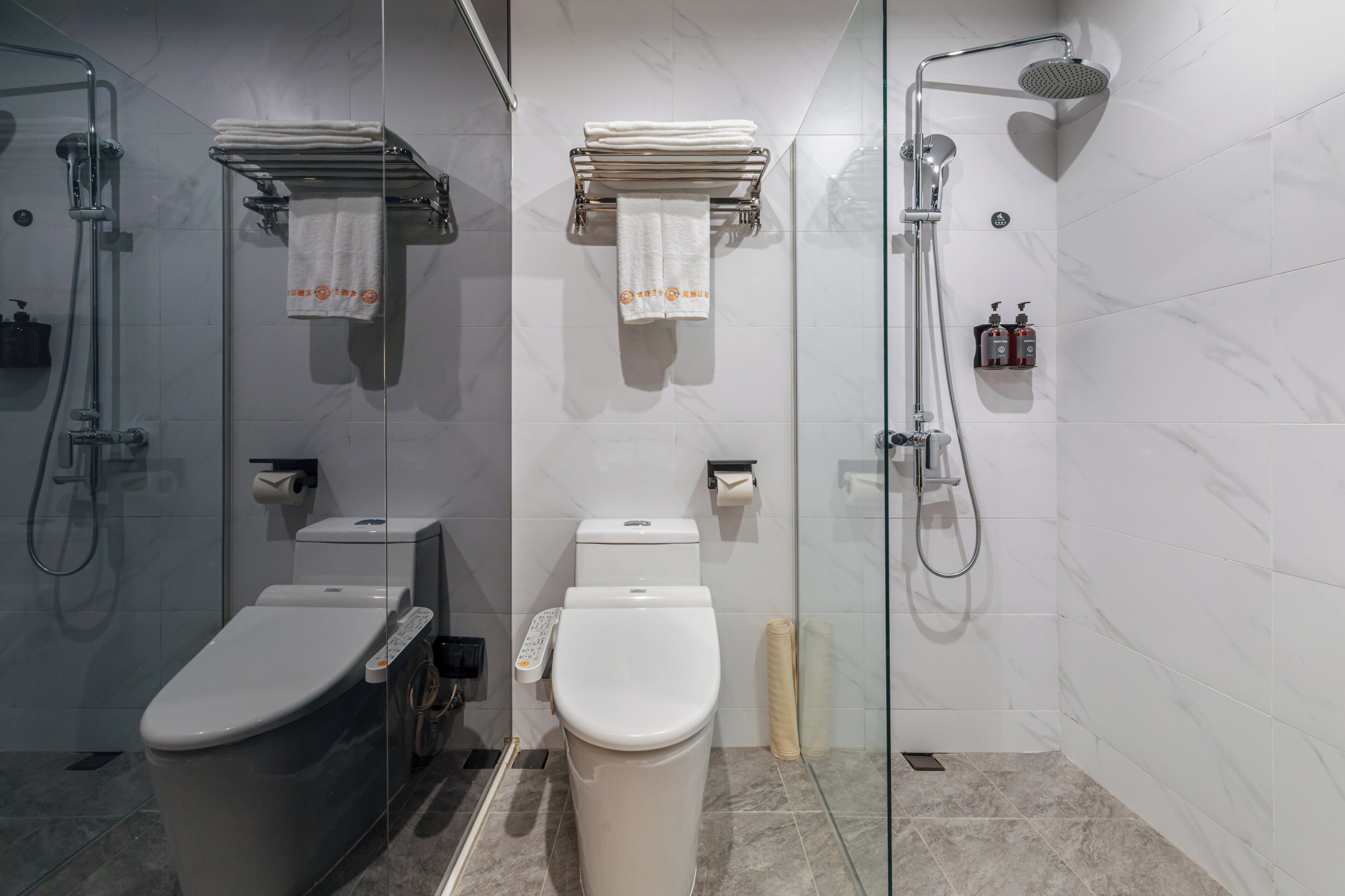A modern bathroom with a glass-enclosed shower, a toilet, and a bidet.