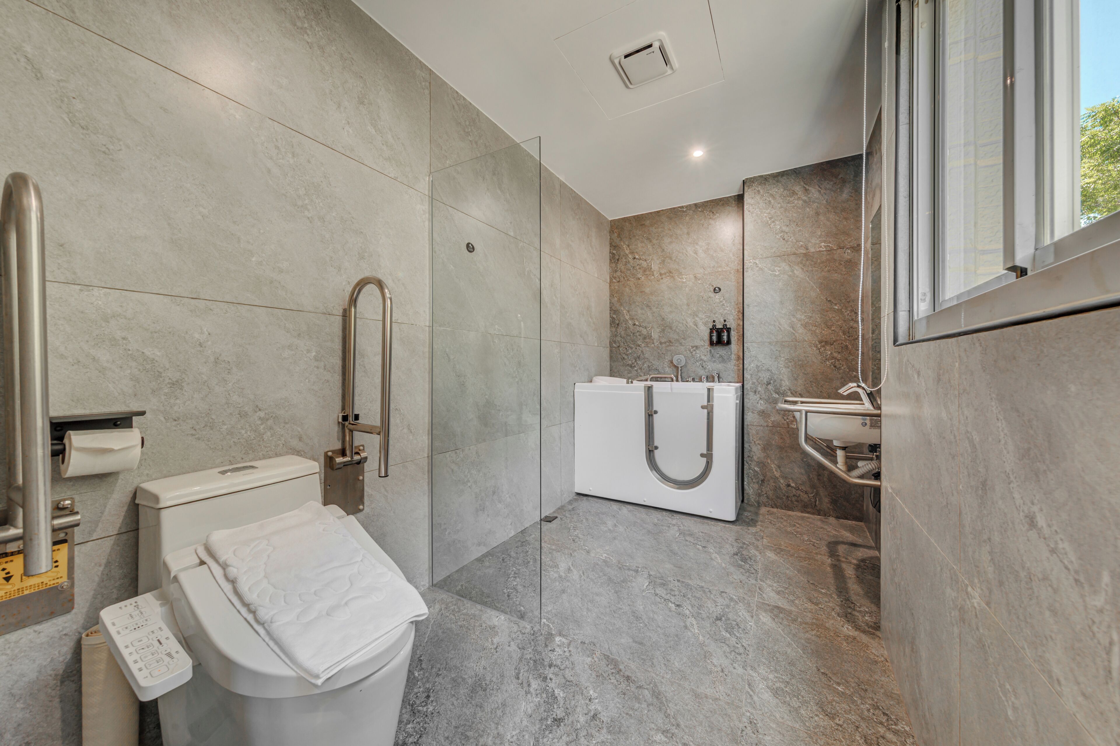 Un baño moderno con inodoro, bidé y zona de ducha con mampara de vidrio.