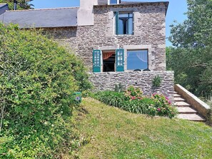 A stone building with a window and a door, surrounded by greenery. - La Sardinerie de la Crique de Porsac'h by Interhome (Le Pouldu)