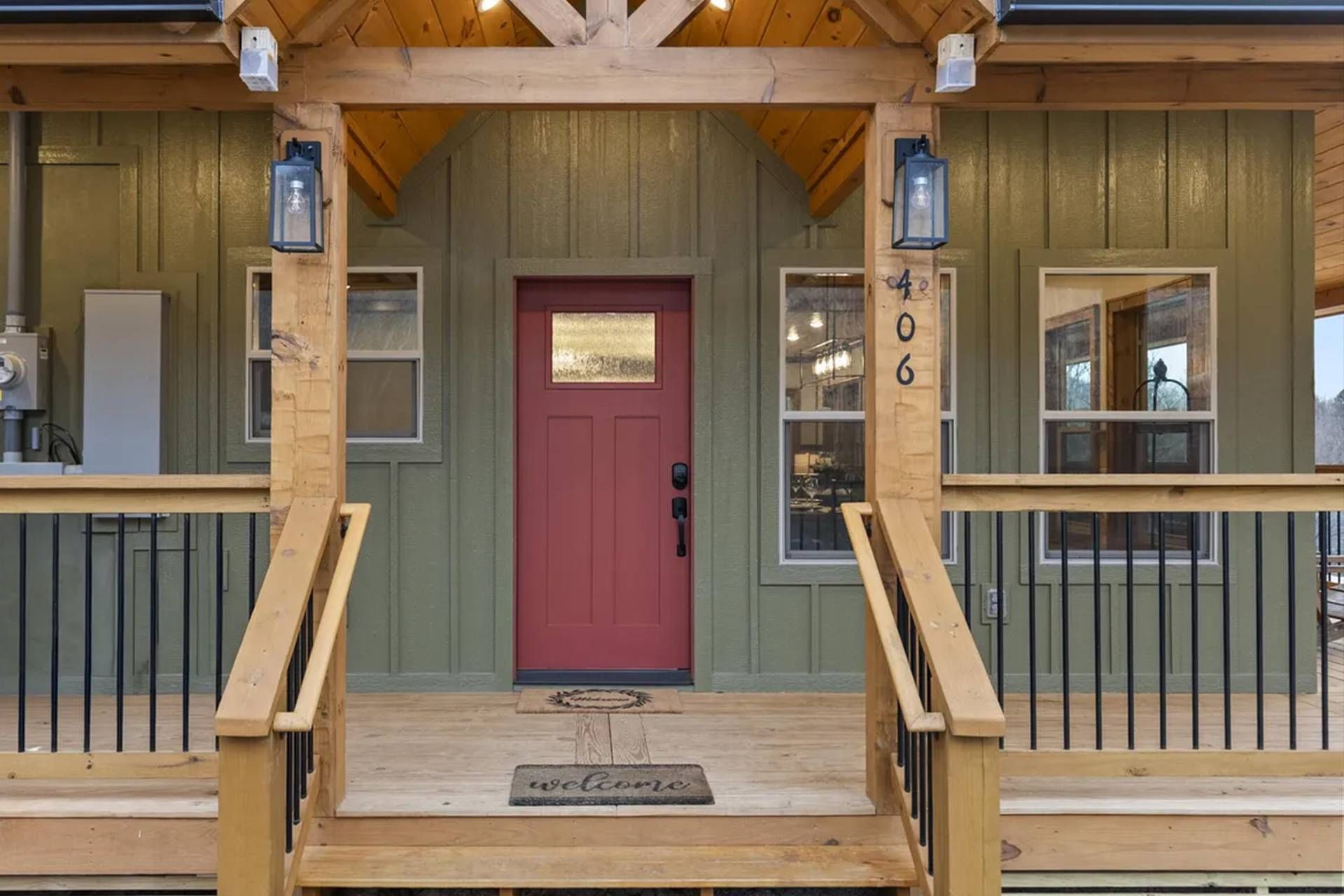 A wooden cabin with a red door, a number '406' on the wall, and a 'welcome' mat at the entrance.
