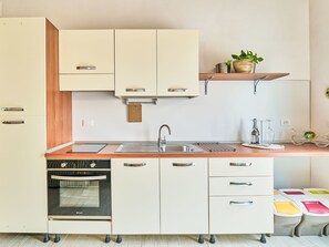 A modern kitchen with a built-in oven, a sink, and a countertop with a drying rack. - La casa del vino by Interhome (Tollo)