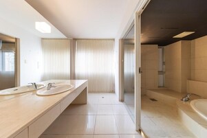 Un baño moderno con dos lavamanos, una bañera grande y una zona de ducha.