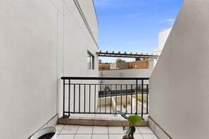 A balcony with a black railing, white walls, and a view of adjacent buildings. - Bright 1-bed Apartment in Neutral Bay (Sydney)